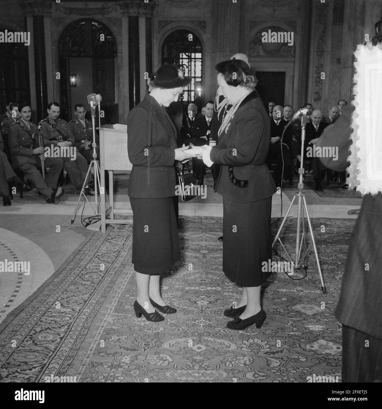 Foto: Sig.ra E.L. den Ouden - v.d. Waag e la regina Juliana. Durante una cerimonia nella sala civica del Paleis op de Dam ad Amsterdam, la regina Juliana informò la vedova del generale S.H. Spoor della sua nomina postuma come Comandante dell'Ordine militare Guglielmo. Alle vedove del Maj-Gen. R. T. Overakker, lut. col. M. P. A. den Ouden, res. Prima lut. J. A. van Bijnen e il sig. T. Dobbe e alla sorella del soldato J. F. Ketting Olivier, la regina ha annunciato che erano stati nominati postumi come cavaliere della quarta classe dell'ordine militare di Guglielmo., 28 settembre 1951, decorazioni, il Foto Stock