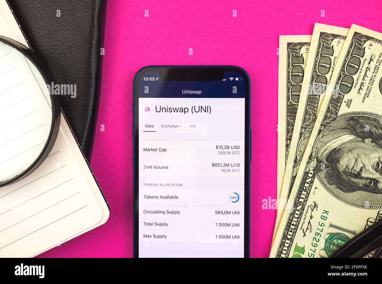 Uniswap UNI Cryptocurrency logo e simbolo primo piano, online banking con il tuo cellulare, spazio di lavoro finanziario sfondo, vista dall'alto Foto Stock