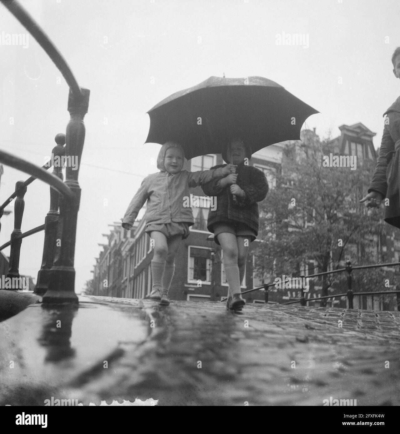 Due bambini sotto l'ombrello della madre sui canali di Amsterdam, 4  novembre 1960, GRAZIE, KLEUTERS, MOEDERS, ombrelli, Paesi Bassi, foto  agenzia stampa del XX secolo, notizie da ricordare, documentario,  fotografia storica 1945-1990,