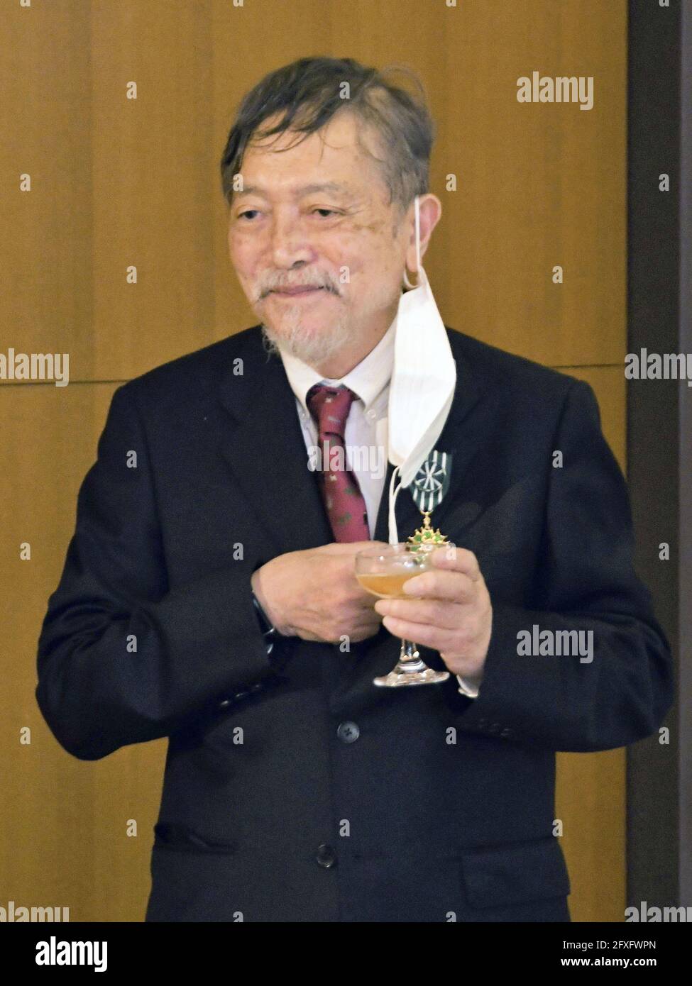 Il romanziere giapponese Natsuki Ikezawa sorride dopo essere stato onorato  come funzionario dell'Ordine delle Arti e delle lettere francese presso la  residenza ufficiale dell'ambasciatore francese a Tokyo il 27 maggio 2021.  Vincitore