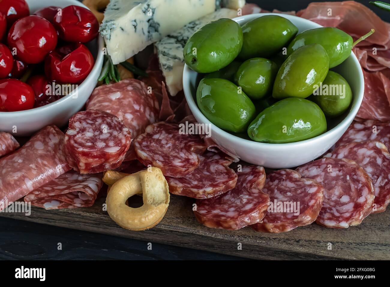 Primo piano di salumi con salumi, olive, peperoni, cracker in stile italiano. Foto Stock