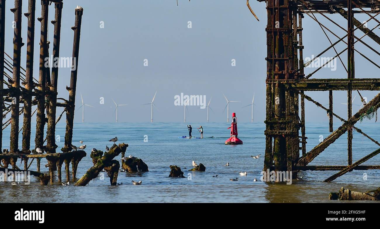 Brighton UK 27 maggio 2021 - i paddle boarders godono di una bella mattinata dietro il West Pier a Brighton con previsioni meteo più calde e soleggiate per arrivare durante il fine settimana di vacanze in banca nel Regno Unito con temperature che si prevede di raggiungere oltre 20 gradi nel Sud-Est : Credit Simon Dack / Alamy Live News Foto Stock