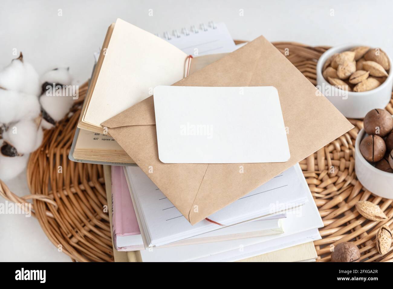 Biglietto da visita su una pila di notebook con busta sul tavolo Foto Stock