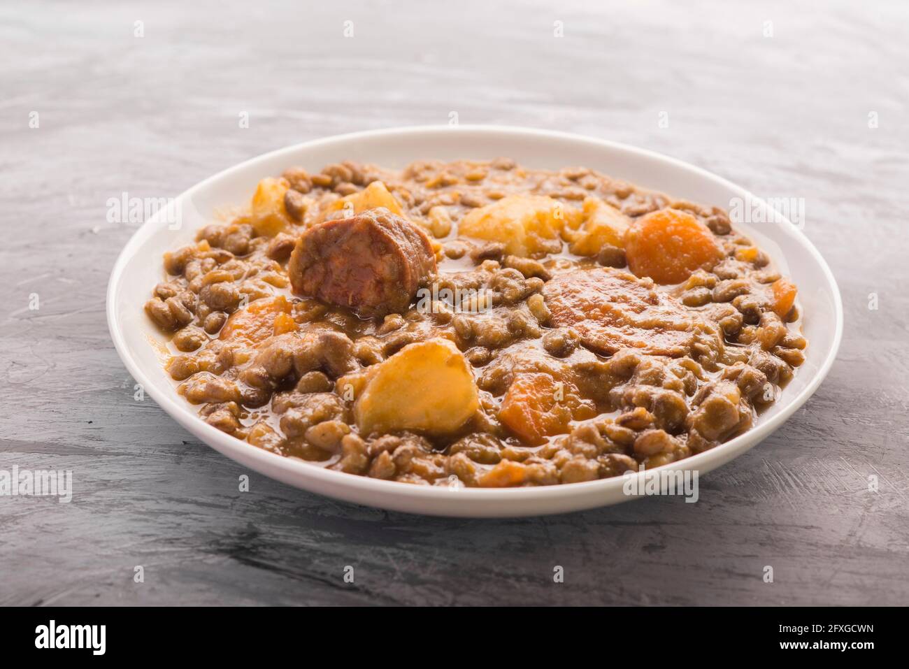 Lenticchie cucinate a mano con patate e carote Foto Stock