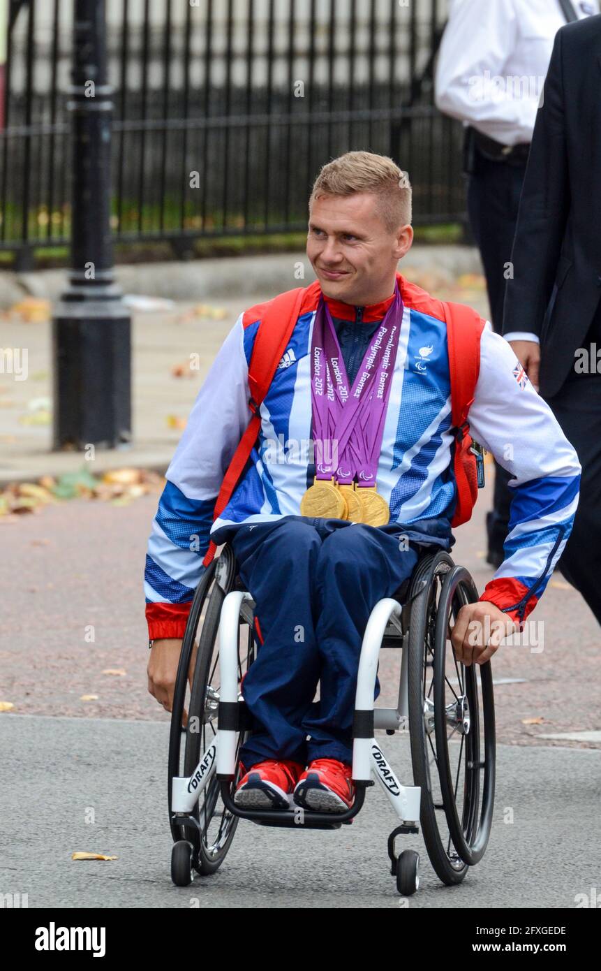 David Weir del Team GB Olympians lascia Buckingham Palace dopo la sfilata della vittoria. Olimpiadi di Londra 2012. Atleta in sedia a rotelle con medaglie Foto Stock