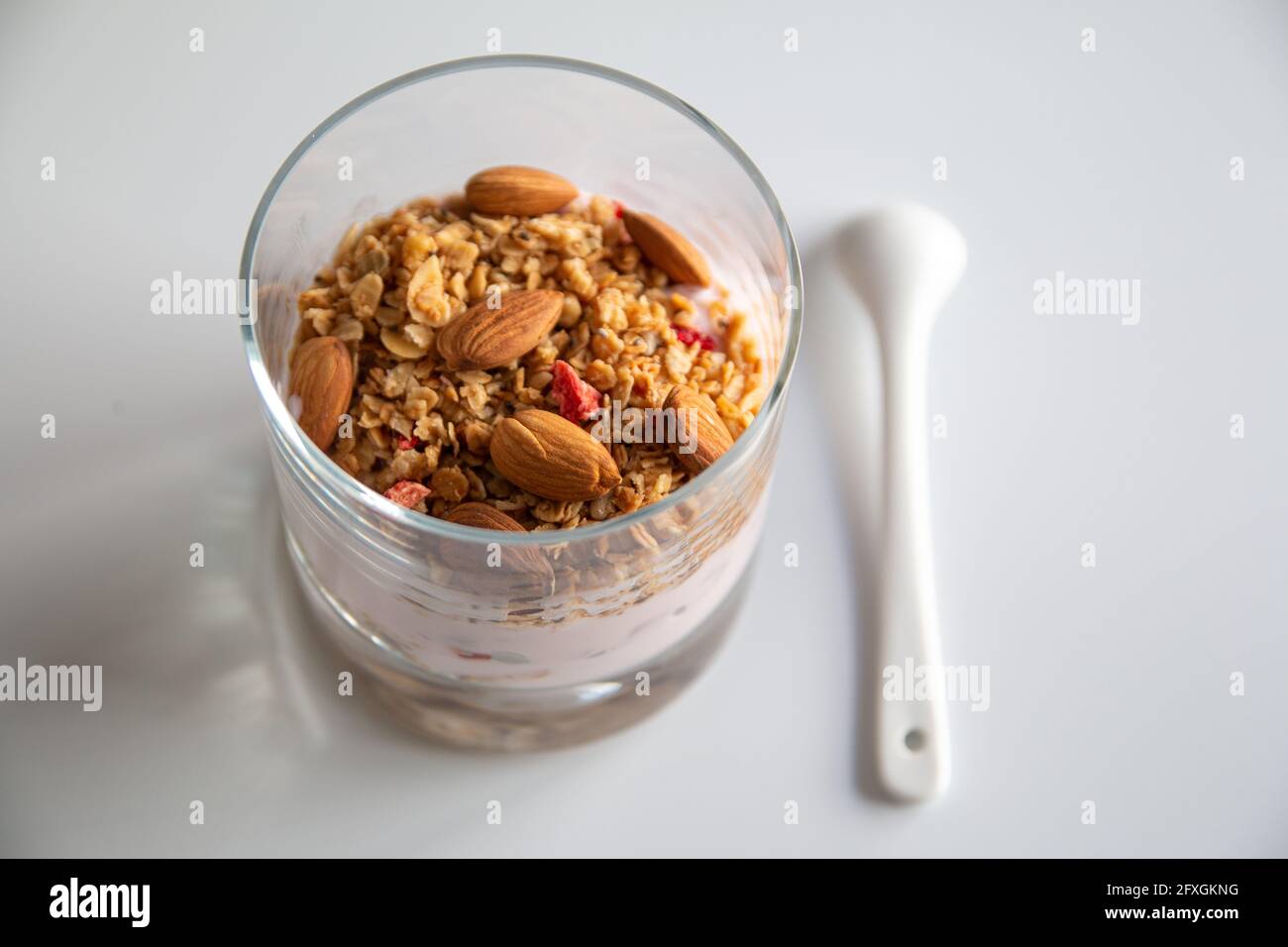Foto di dieta yogurt con muesli e frutta secca, yogurt con cereali e mandorle, sano concetto di colazione con focus selettivo Foto Stock