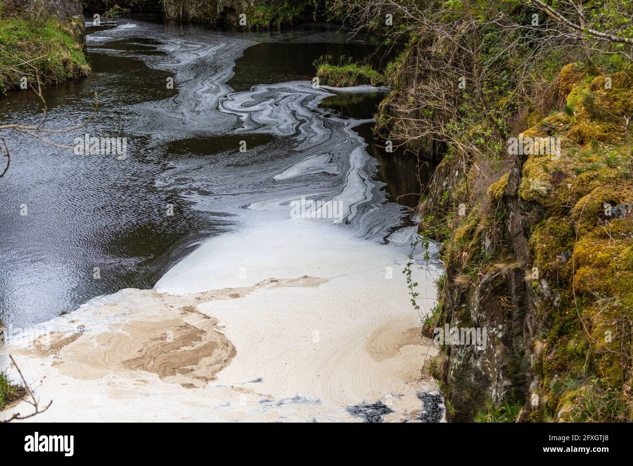Inquinamento idrico in un fiume che scorre da una vecchia miniera di piombo disutilizzata in Galles dopo essere passato attraverso un impianto di trattamento delle acque Foto Stock