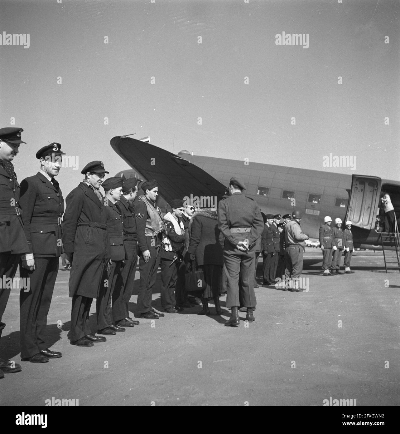 Aeroporto vicino Venlo, dove un Dakota del Naval Air Service è pronto per il volo di ritorno a Londra. La regina Wilhelmina, con dietro il suo principe Bernhard, scuote le mani con i membri dell'equipaggio, 23 marzo 1945, liberazione, visite reali, Seconda guerra mondiale, aerei, campi d'aviazione, Paesi Bassi, foto dell'agenzia stampa del XX secolo, notizie da ricordare, documentario, fotografia storica 1945-1990, storie visive, Storia umana del XX secolo, che cattura momenti nel tempo Foto Stock