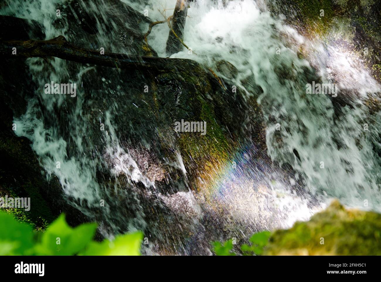 immagine astratta dell'acqua che cade in natura con schiuma e spruzzi e illuminazione solare Foto Stock