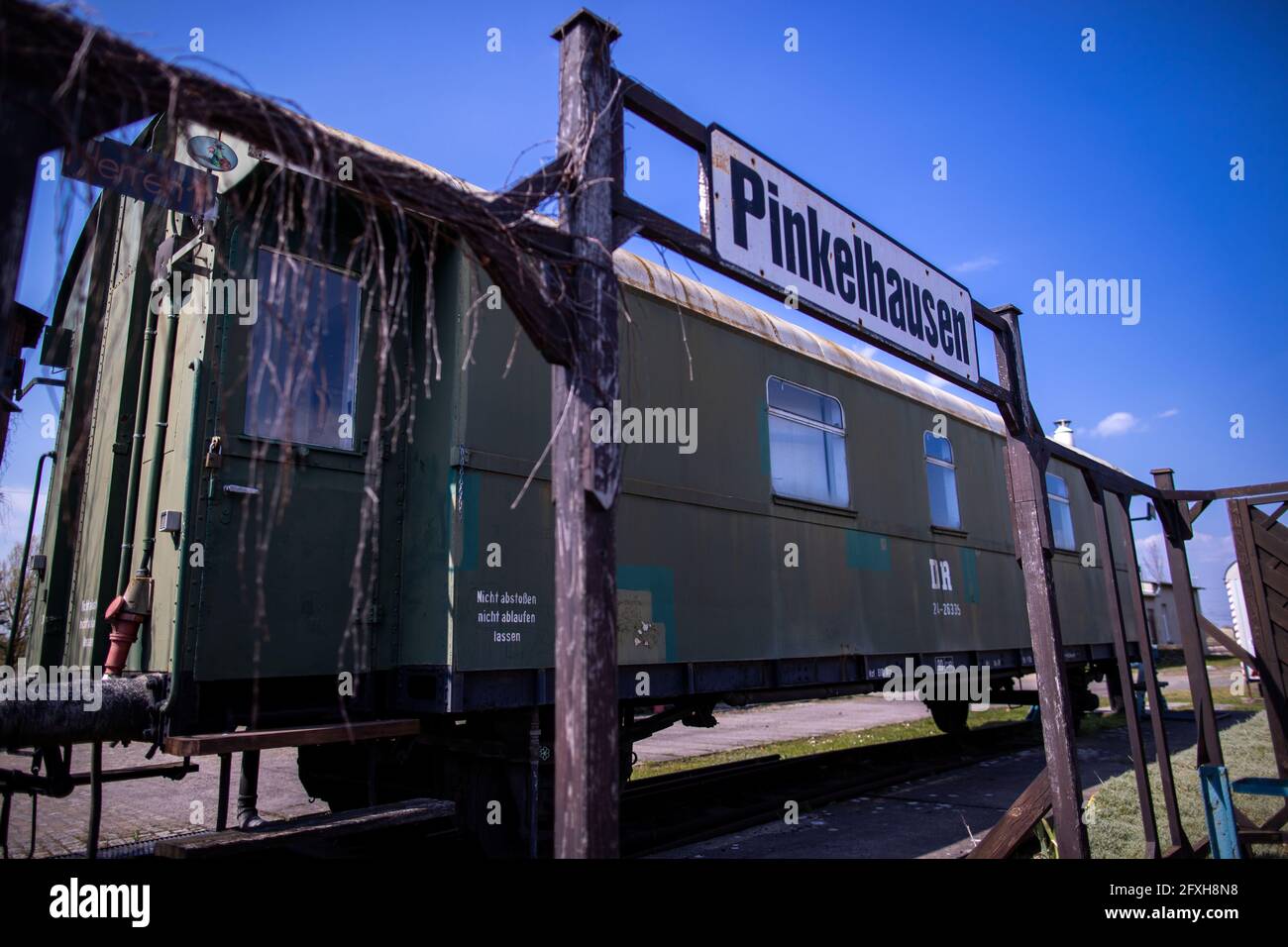 28 aprile 2021, Meclemburgo-Pomerania occidentale, Passerella: Il cartello 'Pinkelhausen' è appeso di fronte al carro della toilette nel centro di esperienza ferroviaria Lokschuppen Pomerania. La struttura è stata chiusa per mesi a causa di misure di protezione Corona. I visitatori potrebbero ammirare la tecnologia ferroviaria con numerose locomotive a vapore e diesel sul sito di 40,000 metri quadrati con la sua storica capanna motore risalente al 1896. La locomotiva celebra un anniversario speciale nel 2021: Avrà 125 anni. Se e in quale forma può essere celebrata dipende dall'ulteriore sviluppo della pandemia. Wi Foto Stock