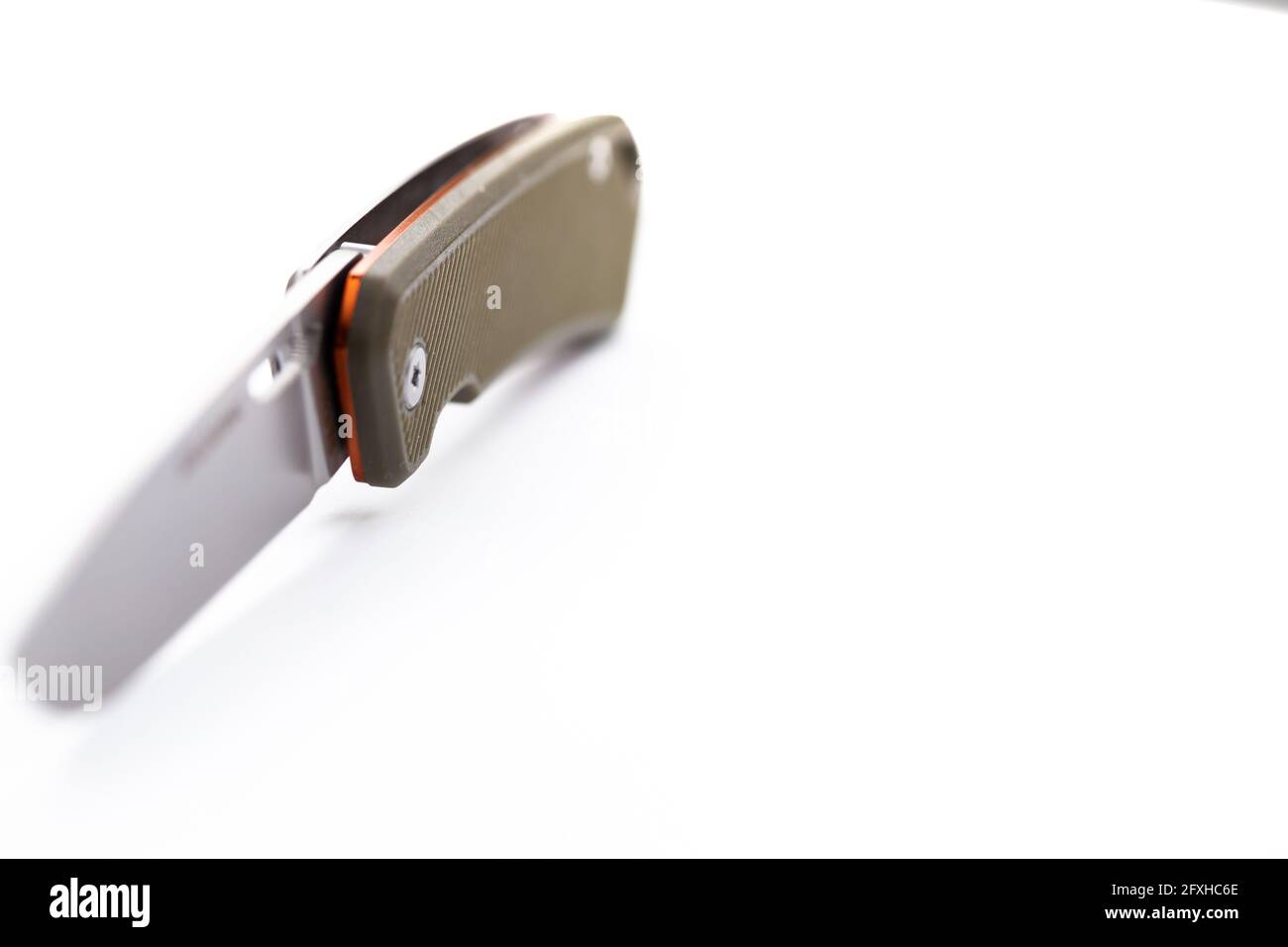 Un piccolo coltello di caccia pieghevole isolato su sfondo bianco. Foto scattata sotto la luce artificiale morbida. Foto Stock