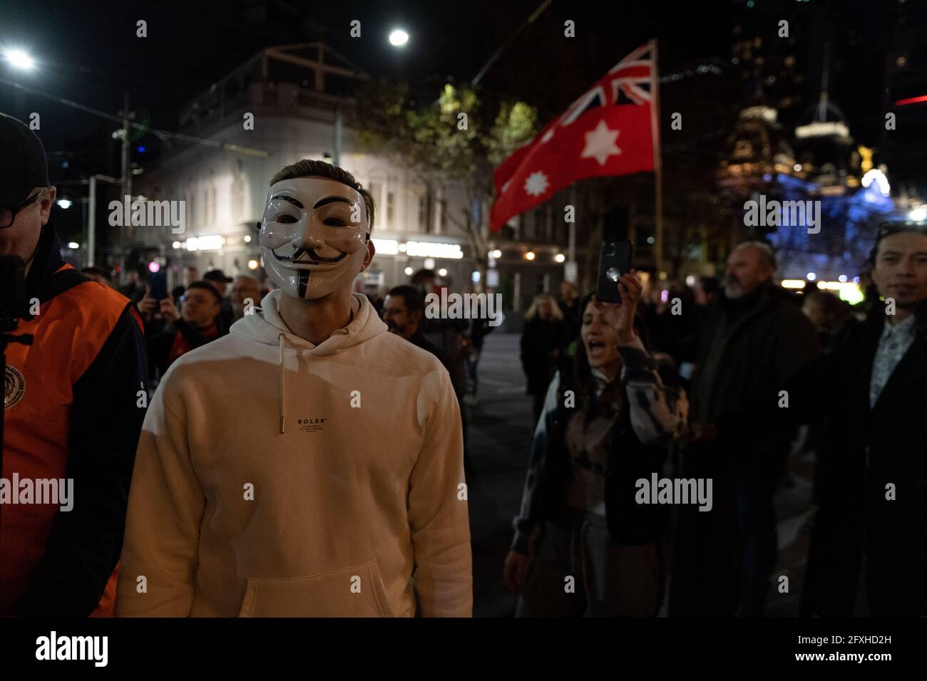 Melbourne, Australia 27 maggio 2021, un manifestante in una maschera Guy Fawkes nella folla durante un raduno di manifestanti anti anti anti-lockdown al di fuori della stazione di Flinders Street di Melbourne, dove i manifestanti vi esprimono opinioni sul blocco di 7 giorni che dovrebbe iniziare a mezzanotte questa sera. Foto Stock