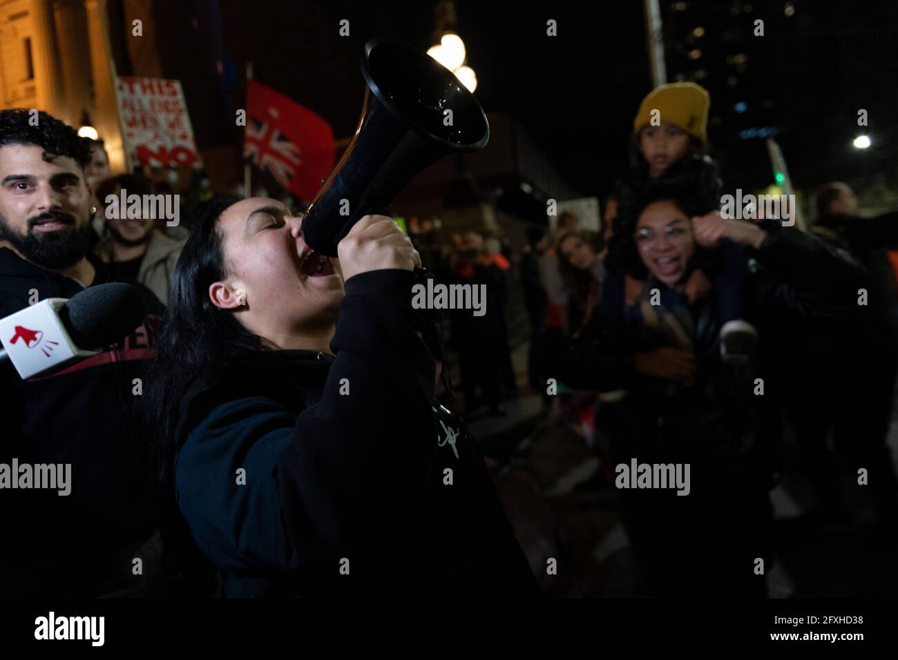 Melbourne, Australia 27 maggio 2021, UNA protesta femminile grida in un mega-telefono durante un raduno di manifestanti anti anti-lockdown al di fuori della Flinders Street Station di Melbourne, dove i manifestanti vi esprimono opinioni sul blocco di 7 giorni che dovrebbe iniziare a mezzanotte questa sera. Foto Stock