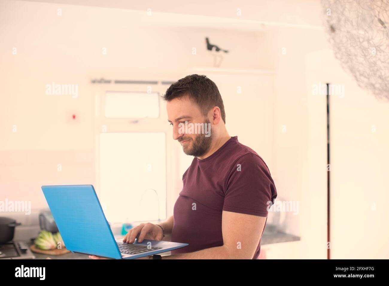 Uomo che lavora da casa al laptop Foto Stock