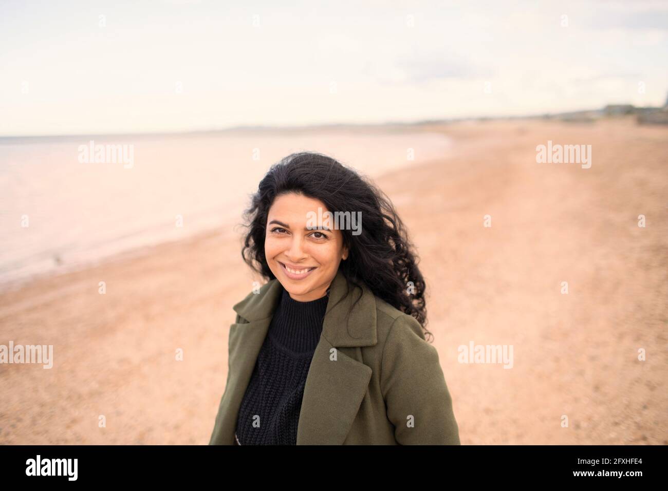 Ritratto felice bella donna sulla spiaggia dell'oceano invernale Foto Stock
