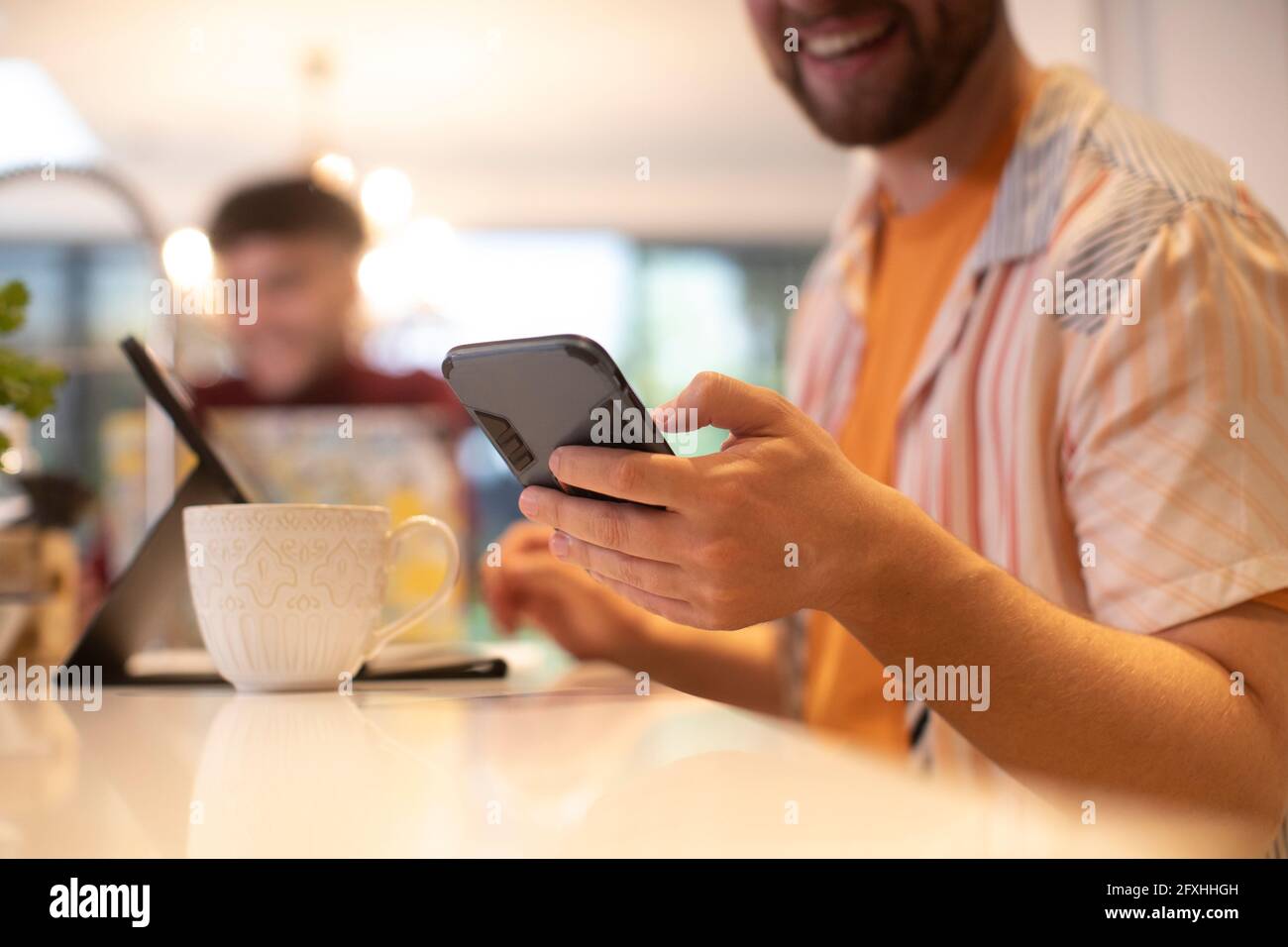 Primo piano di un giovane che utilizza lo smartphone a casa Foto Stock