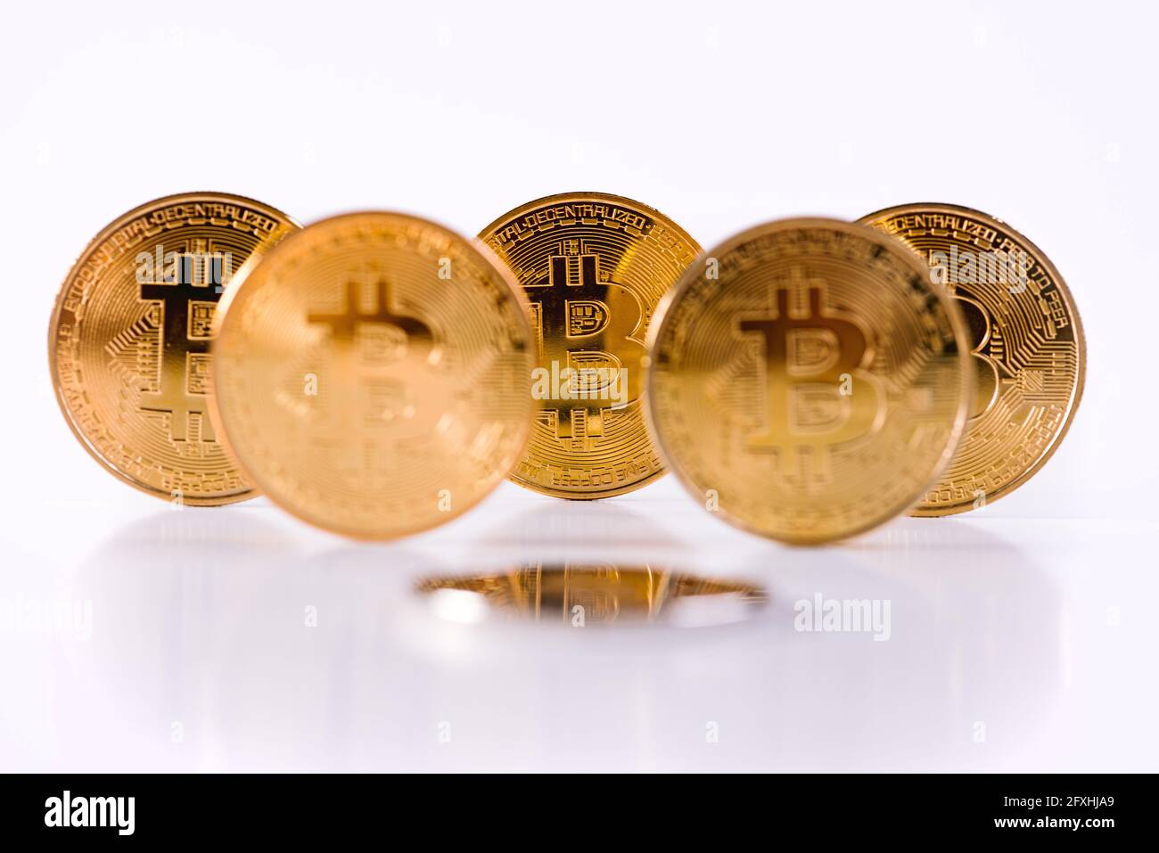 Monete d'oro Crypto Bitcoin in piedi ordinati in forma triangolare sul tavolo isolato su sfondo bianco. Copia spazio. Concetto di denaro virtuale. Estrazione mineraria o. Foto Stock