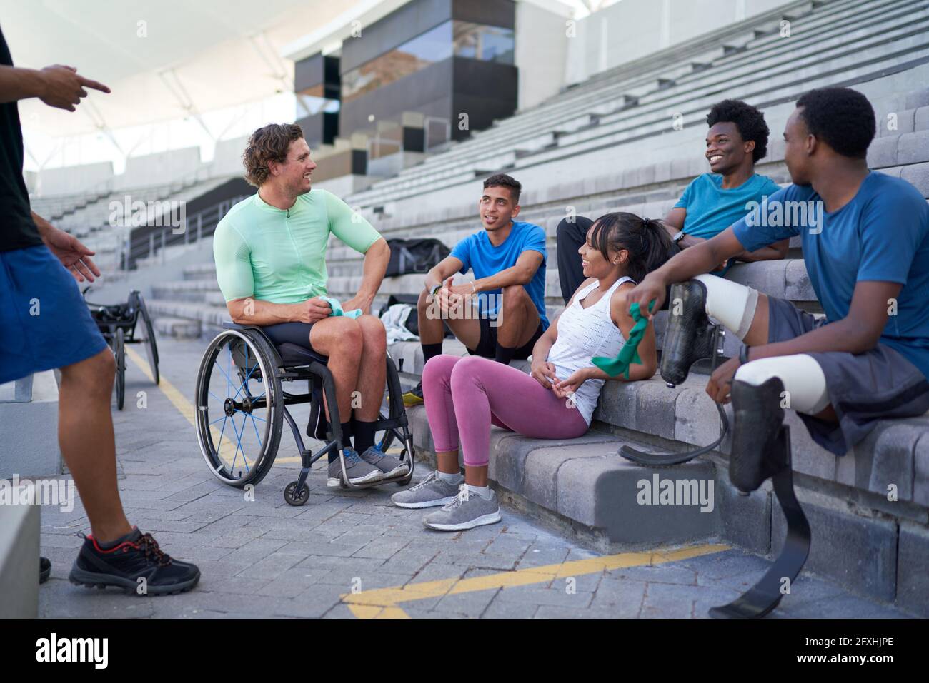 Diversi giovani atleti che parlano nei bleachers dello stadio Foto Stock