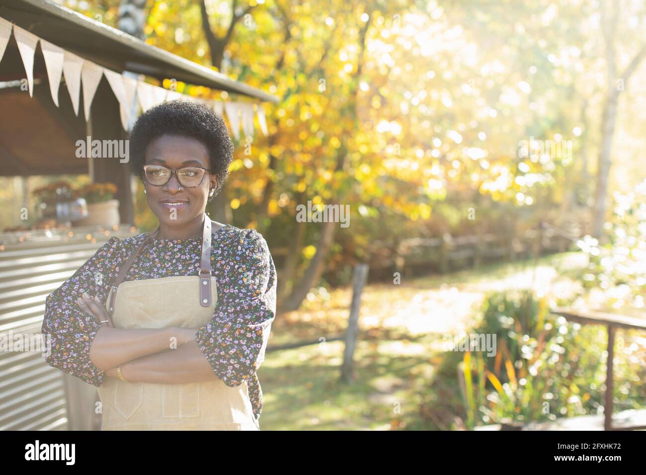 Ritratto sicuro proprietario del carrello alimentare femminile nel soleggiato parco autunnale Foto Stock