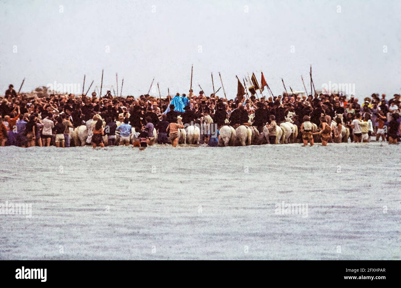 I Gardiani sui loro cavalli formano un semicerchio nel mare in cui le figure sante sono trasportate in acqua. Saintes-Maries-de-la-Mer, Francia Foto Stock