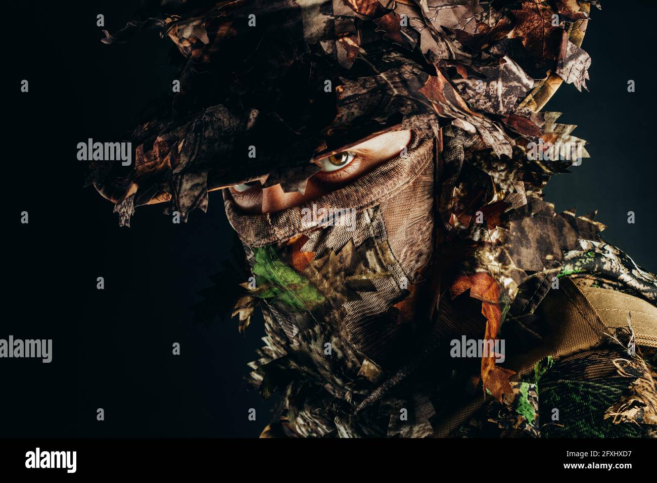 Foto di un volto di cacciatore maschile a panama cappello e guillie foresta mimetizzato. Foto Stock