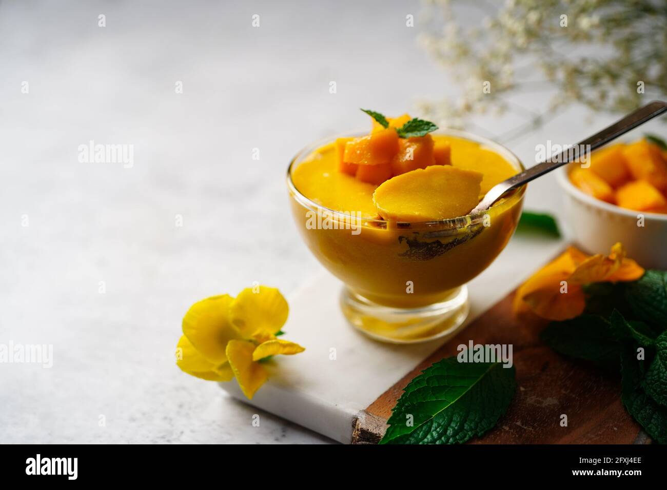 Mousse di mango fatta in casa con mango tagliato e guarnitura di menta, fuoco selettivo Foto Stock