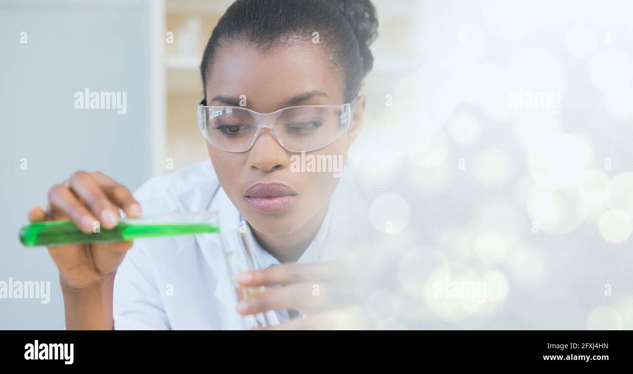 Composizione di una scienziata femminile contenente una provetta con liquido verde in laboratorio e spazio di copia Foto Stock