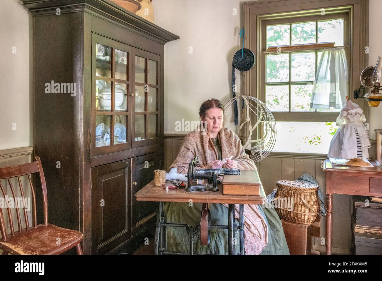 Toronto, Canada-May 30, 2019: la sarta donna all'interno della casa McKenzie. La scena è visto in Black Creek Pioneer Village che è un famou Foto Stock