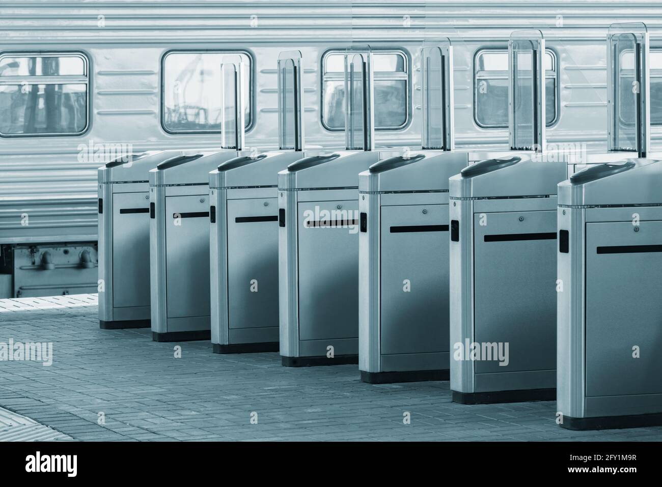 Tornelli con lettori di schede elettroniche sulla piattaforma della stazione. Foto Stock