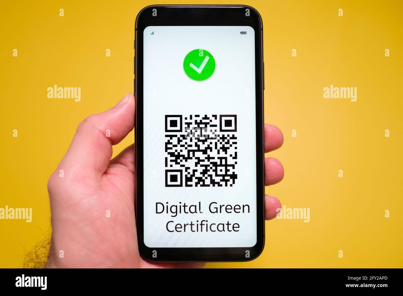 Uno smartphone con passaporto elettronico immuno digitale salute, Covid passare con codice QR in mano mans sullo sfondo giallo. Foto Stock