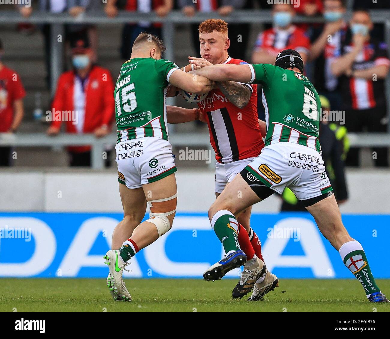 Harvey Livett (20) di Salford Red Devils è affrontato da Chris Hill (8) e Matt Davis (15) di Warrington Wolves Foto Stock