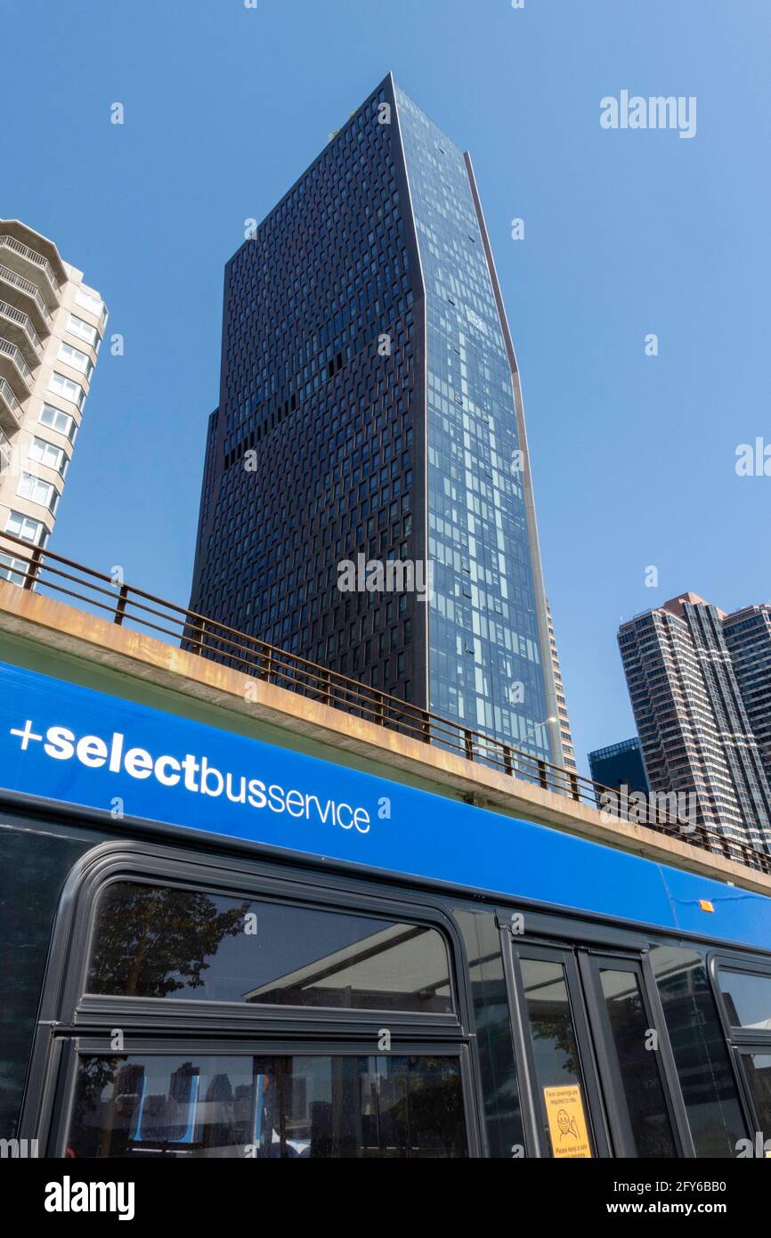 Guardando verso gli edifici in rame americano con un autobus selezionato in primo piano a New York City, Stati Uniti Foto Stock