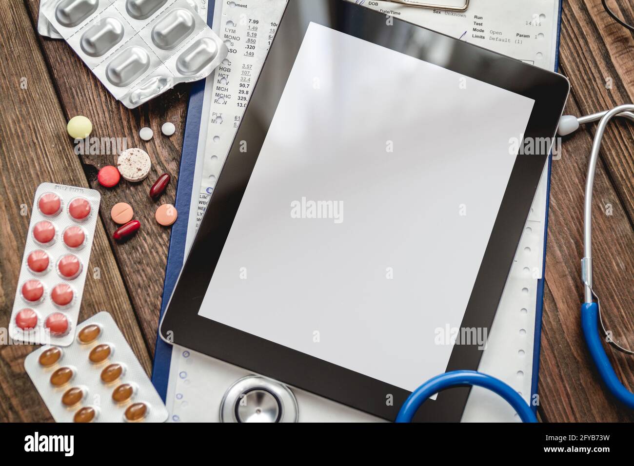 Scheda medica del paziente, stetoscopio, compressa e pillole Foto Stock