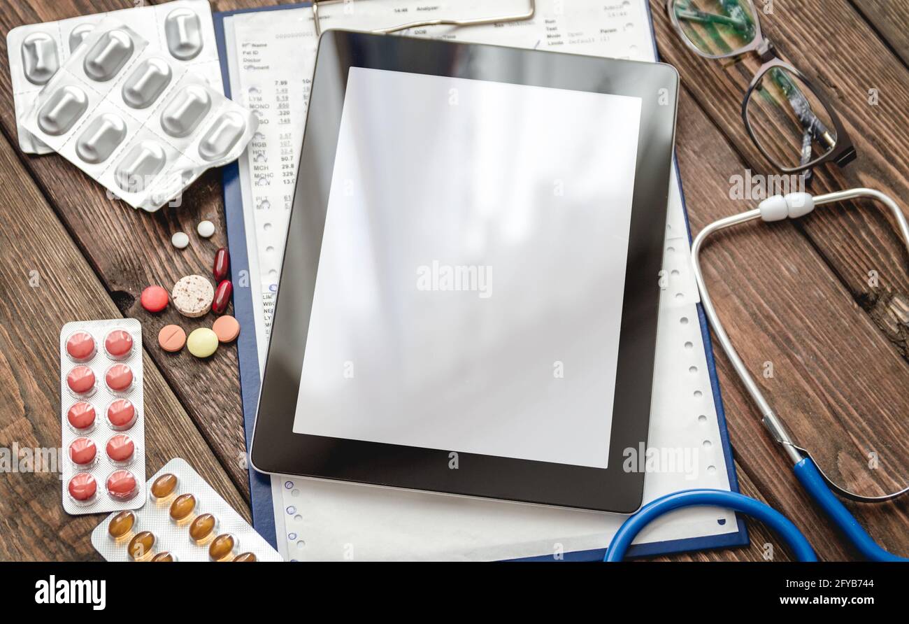 Scheda medica del paziente, stetoscopio, compressa e pillole Foto Stock