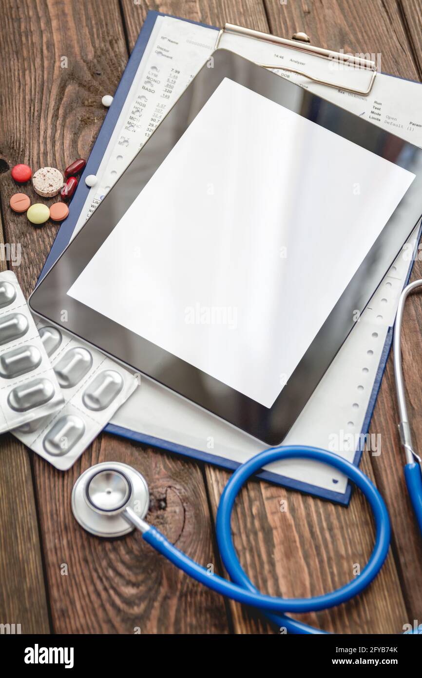 Scheda medica del paziente, stetoscopio, compressa e pillole Foto Stock