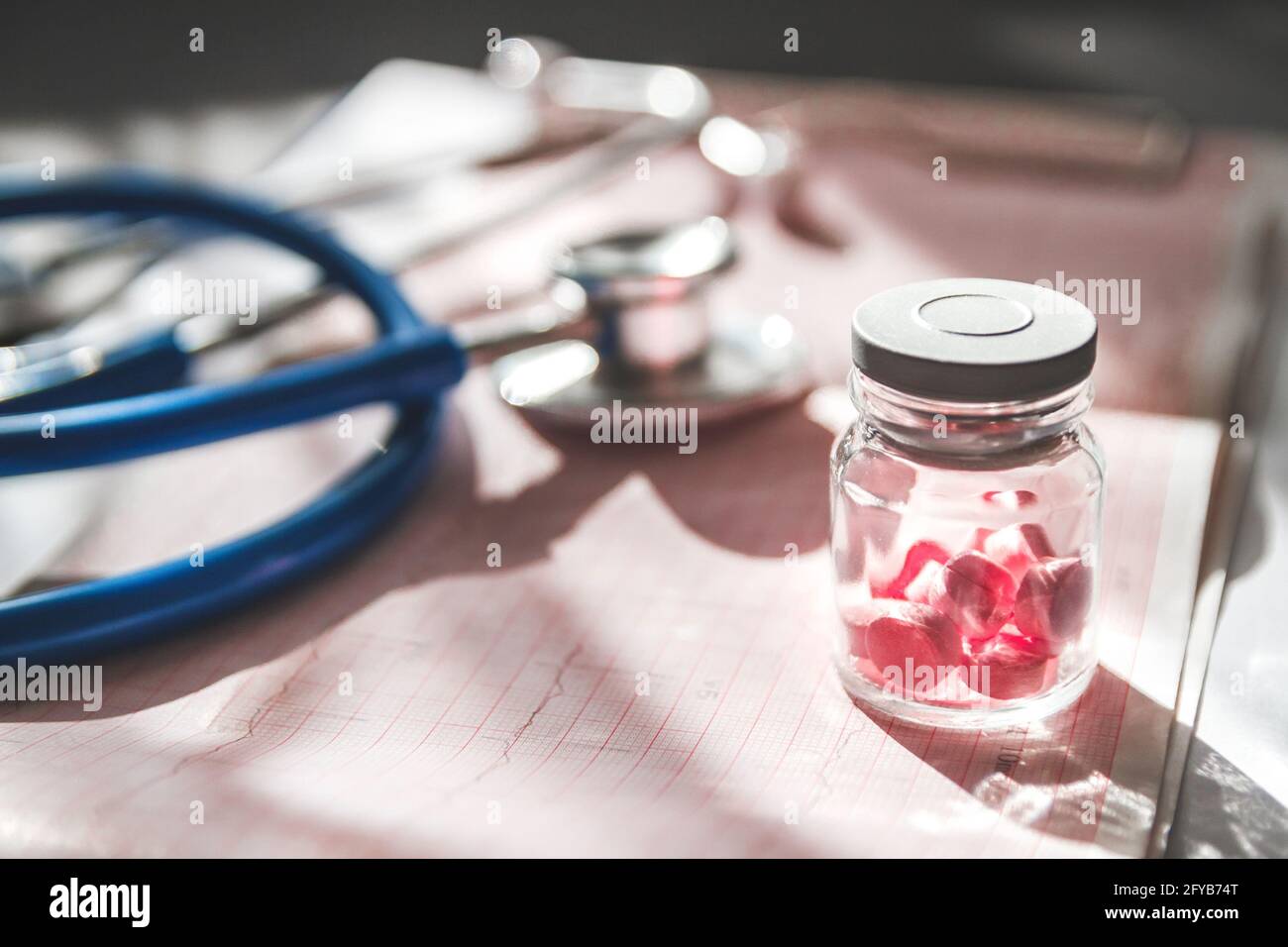 Primo piano della scheda medica di un paziente, uno stetoscopio e pillole Foto Stock
