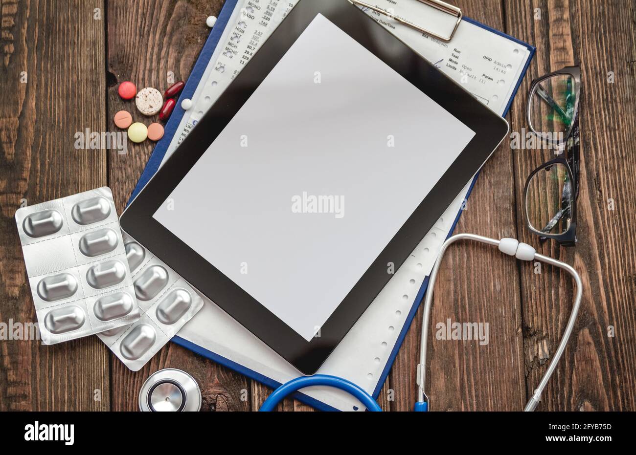 Scheda medica del paziente, stetoscopio, compressa e pillole Foto Stock