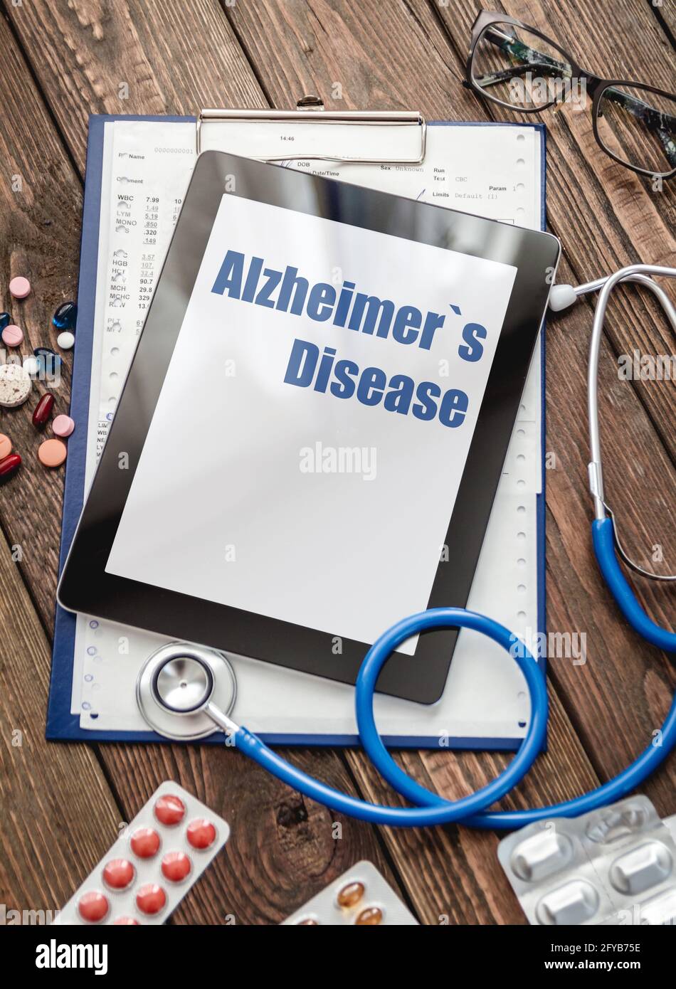 Scheda medica del paziente, stetoscopio, compressa e pillole Foto Stock