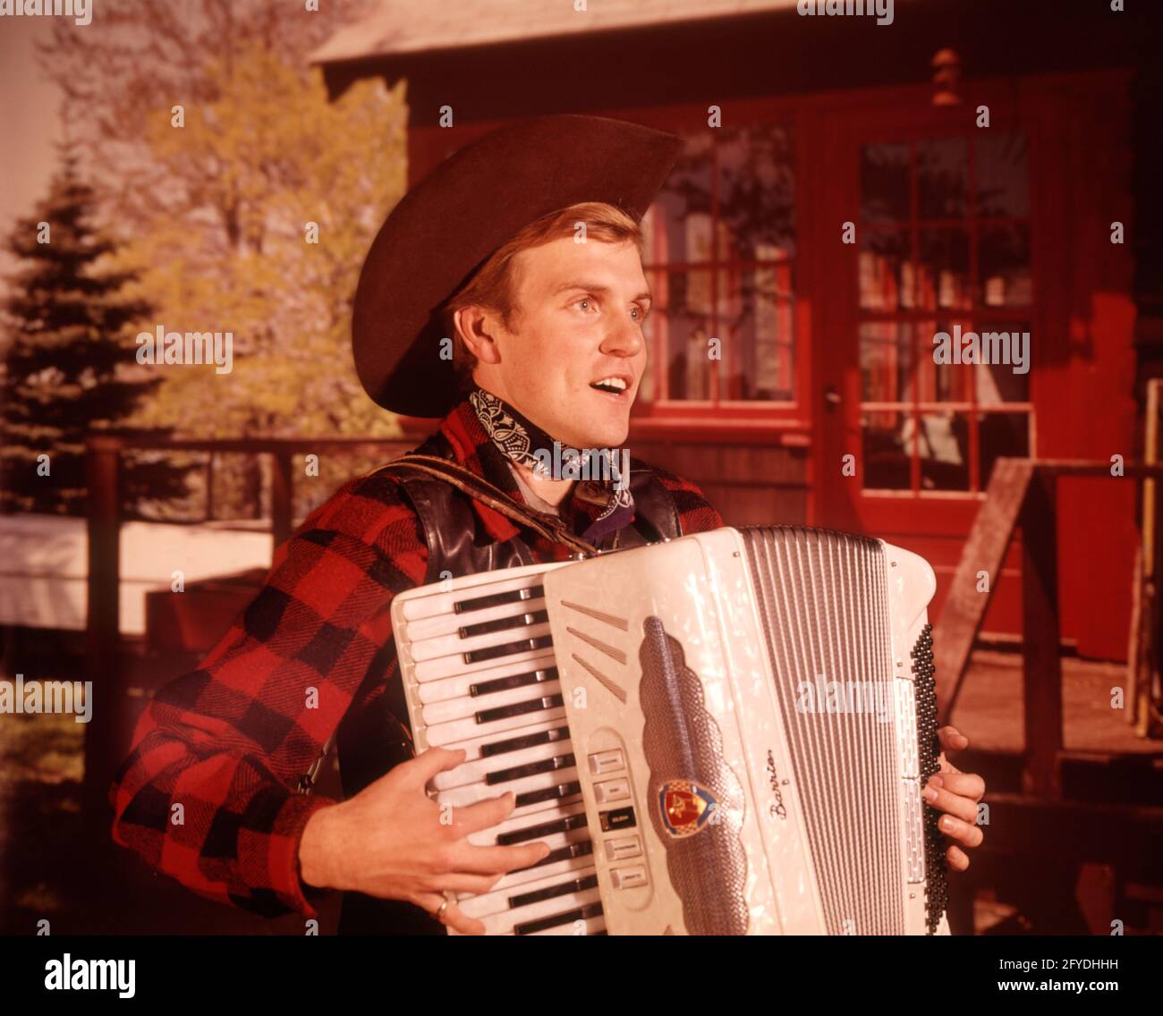 COWBOY HAT, UOMO DEGLI ANNI '60, CANTA MUSICA SUONANDO UN GIORNALE DI FISARMONICA PEARL MOUNTAIN CABIN COUNTRY CANTANTE WESTERN VOCAL - KM1283 HAR001 HARS SPAZIO PER LA COPIA PERSONE DI MEZZA LUNGHEZZA PERSONAGGIO ADULTO UOMINI WESTERN CABINA CANTARE INTRATTENIMENTO CONFIDENCE RESORT ARTI DELLO SPETTACOLO OCCUPAZIONE FISARMONICA LOG ESECUTORE RICREAZIONE CANZONE VOCE VOCAL PAESE E WESTERN ENTERTAINER OCCUPAZIONI ATTORI ELEGANTE CAPO-WARE CAMICIA PLAID COMUNICARE CREATIVITÀ ANIMATORI ESECUTORI RELAX GIOVANE ADULTO UOMO ETNIA CAUCASICA HAR001 VECCHIO STILE Foto Stock