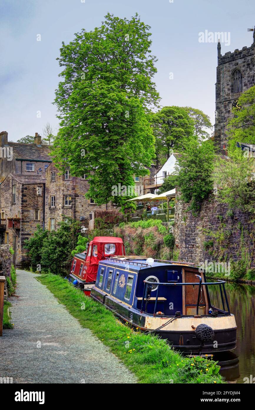 Chiatte ormeggiate sul canale Springs Branch, vicino a edifici storici nella città mercato di Skipton Foto Stock