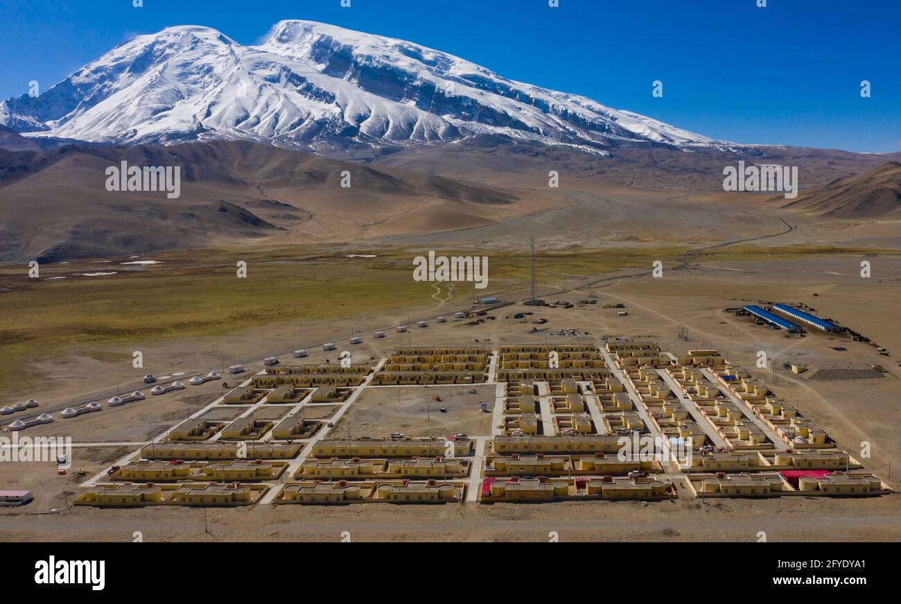 (210528) -- URUMQI, 28 maggio 2021 (Xinhua) -- Foto aerea scattata il 17 maggio 2021 mostra una vista del Villaggio Subarx ai piedi della Muztagh ATA nella Contea di Akto, nella Regione Autonoma Xinjiang Uygur della Cina nordoccidentale. Bikmirza, un pastore di 24 anni di Kirghiz, è nato e cresciuto ai piedi del Muztagh ATA, una vetta con un'altitudine di oltre 7,500 metri, nei Pamirs della regione autonoma cinese Xinjiang Uygur. Ha iniziato a lavorare come guida per aiutare gli scalatori a trasportare attrezzature e forniture all'età di 18 anni. Arrampicata Muztagh ATA, un simbolo di coraggio, è anche considerato come la cerimonia di arrivo Foto Stock