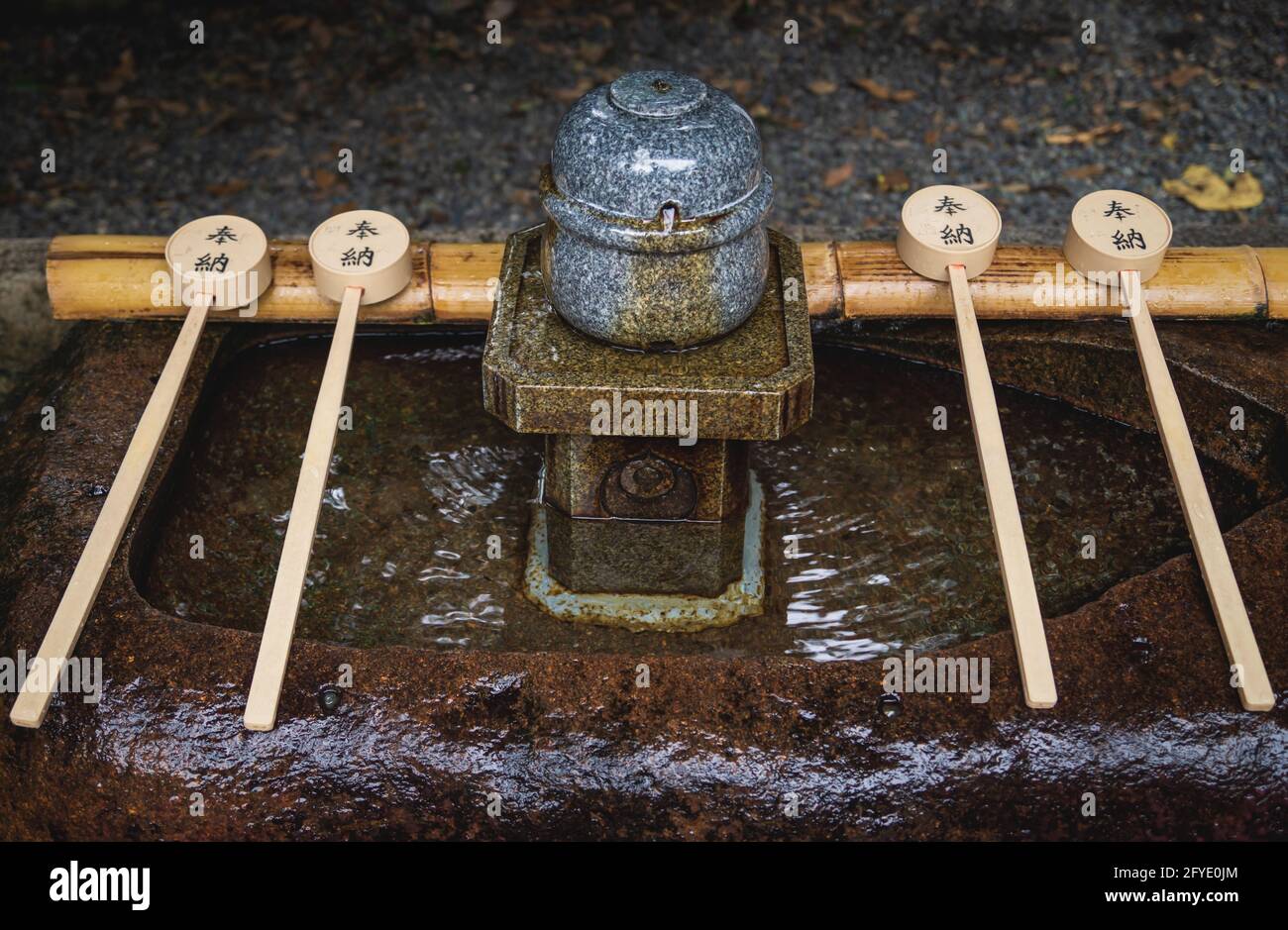 Fontana d'acqua purifica giapponese, chiamata chozubachi, al santuario di Fushimi Inari Taisha, Kyoto, Giappone Foto Stock
