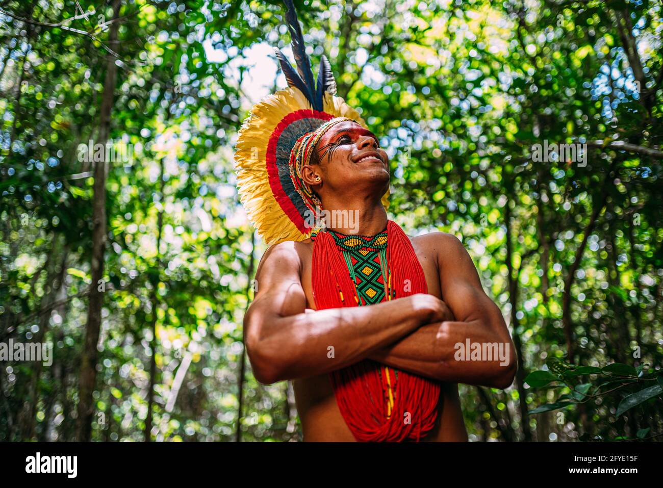 Indiano della tribù Pataxó, con erindirizzo di piuma. Giovane brasiliano  indiano guardando a destra, sorridente e le braccia incrociate Foto stock -  Alamy