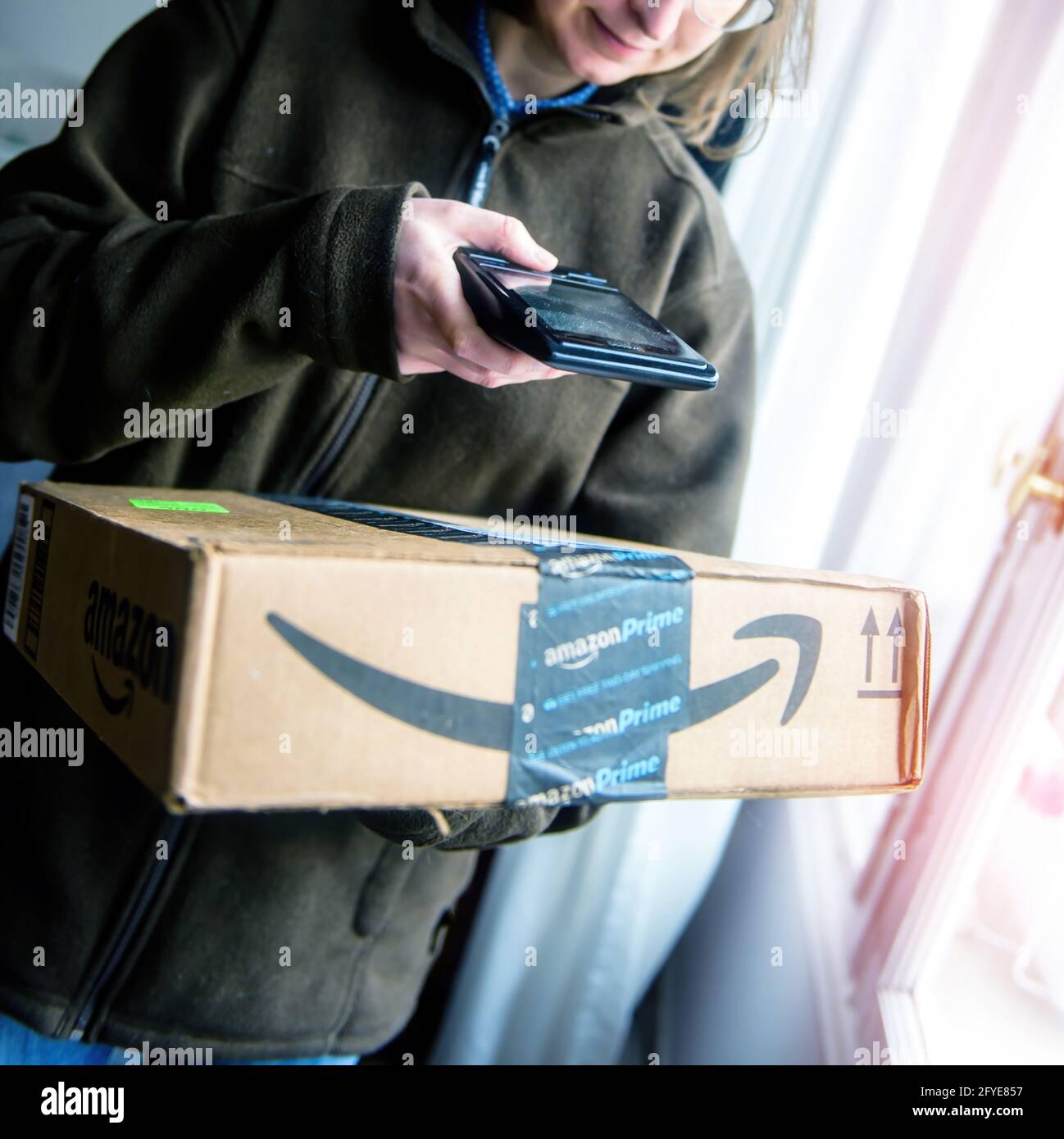 Spedizione di cartone con corriere donna da Amazon prime Foto stock - Alamy