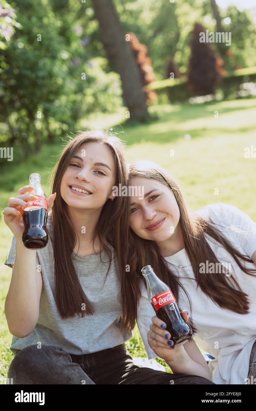 Buche, Ucraina, 26 maggio 2021. Belle giovani donne adolescenti in una calda giornata estiva con bottiglie di vetro di Coca-Cola nelle loro mani, sorridendo felice. Morbido Foto Stock