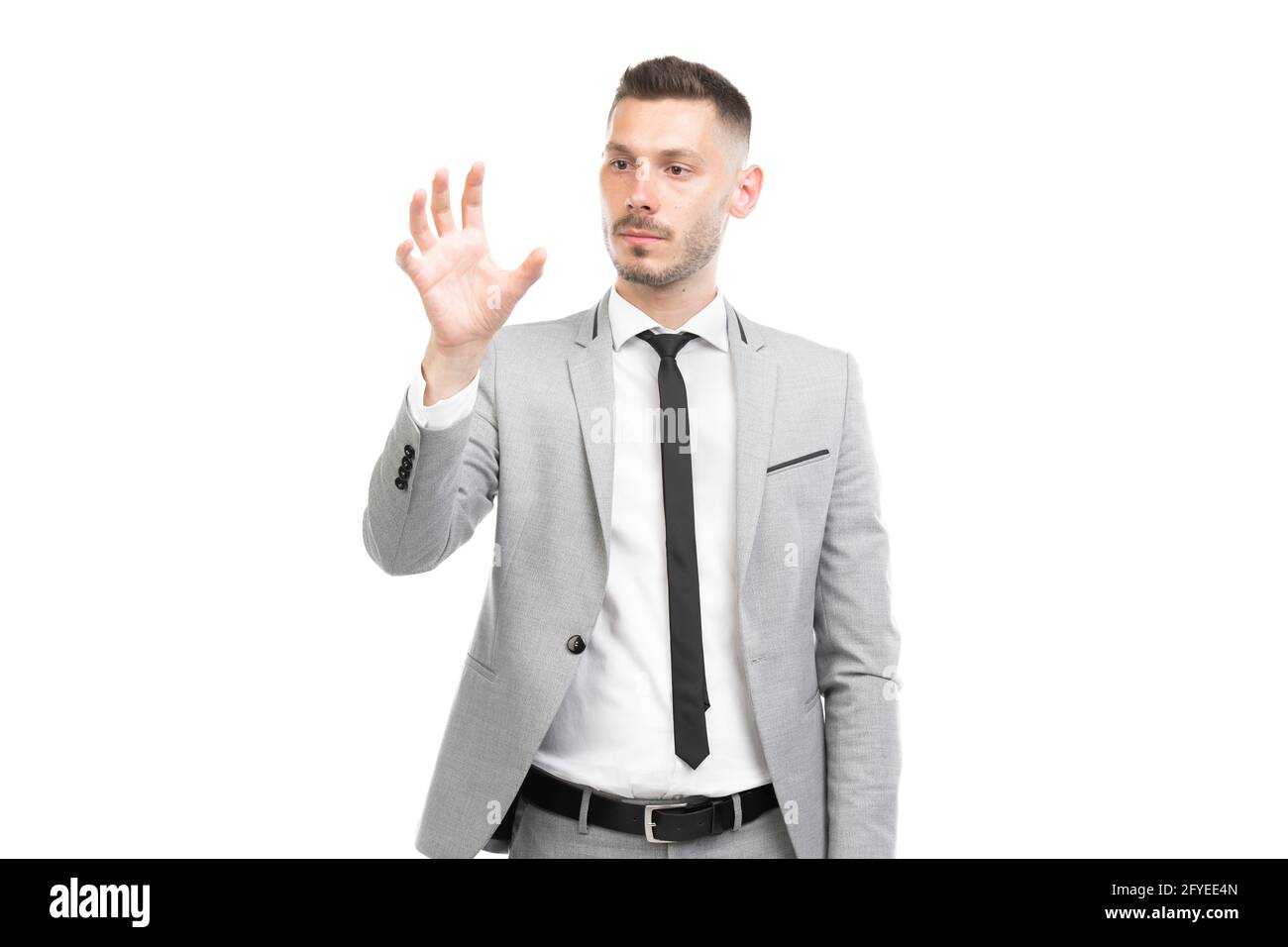 Ritratto orizzontale medio di bel giovane adulto caucasico che indossa abito  grigio con cravatta nera cercando di afferrare qualcosa, sfondo bianco Foto  stock - Alamy