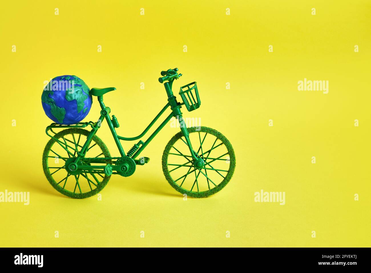 3 Giugno Giornata Mondiale della bicicletta. Bicicletta verde su sfondo giallo. Conservazione dell'ambiente. Foto Stock