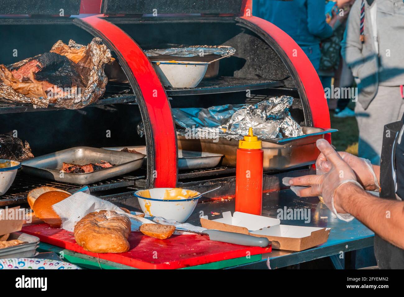 Primo piano di una grande griglia all'aperto e di un banco di vendita barbecue. Festa del barbecue nel parco cittadino. Foto Stock