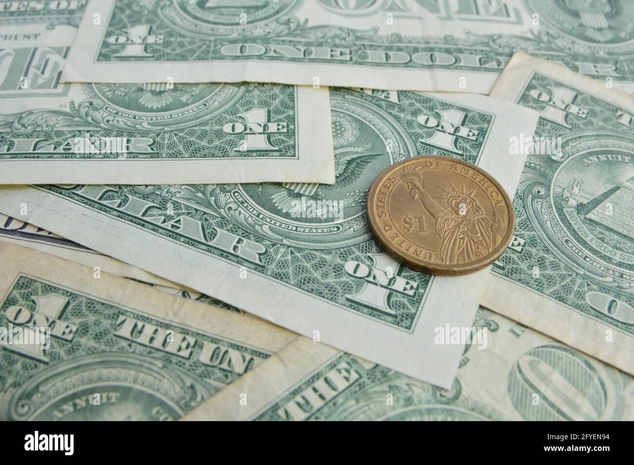 Primo piano di una vecchia moneta in dollari USA sullo sfondo di una banconota in dollari USA Foto Stock