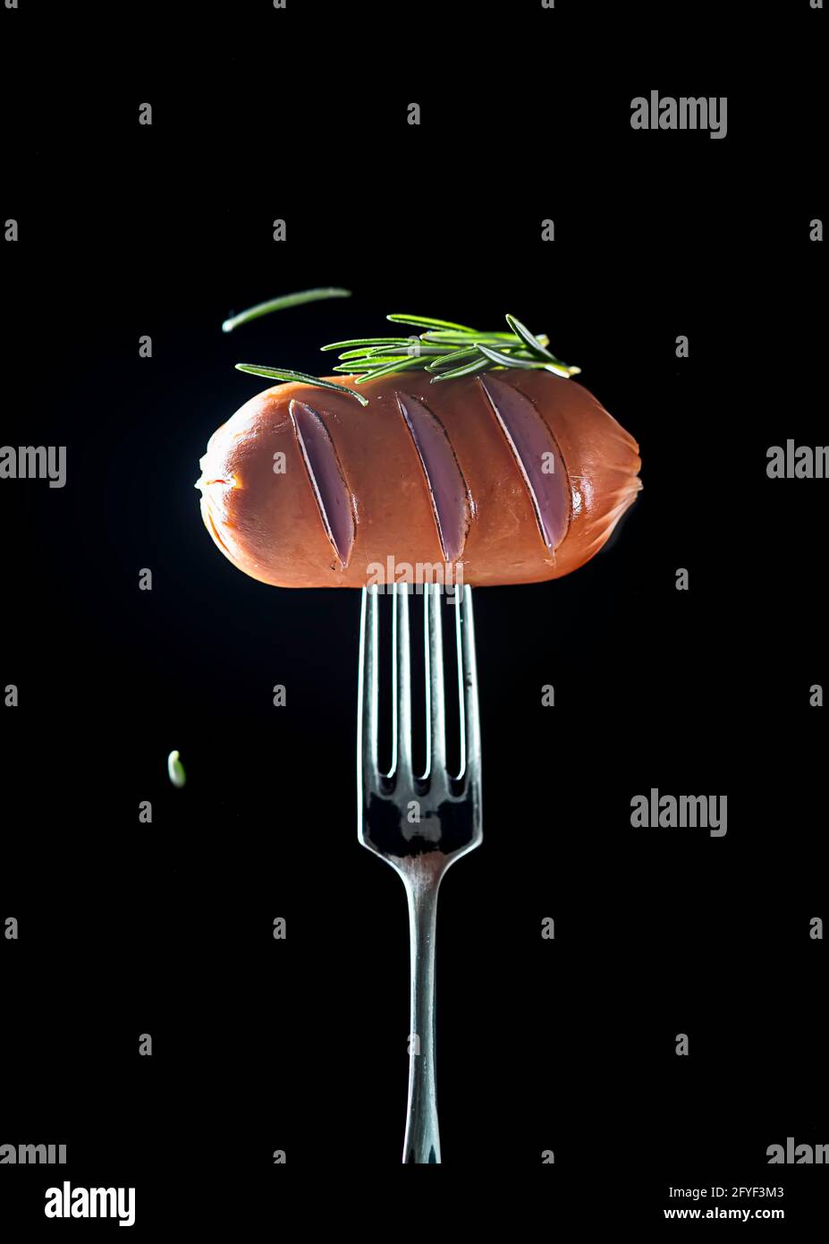 Salsicce di carne piccanti su una forchetta su fondo nero. Cibo gustoso. Spazio di copia. Foto Stock